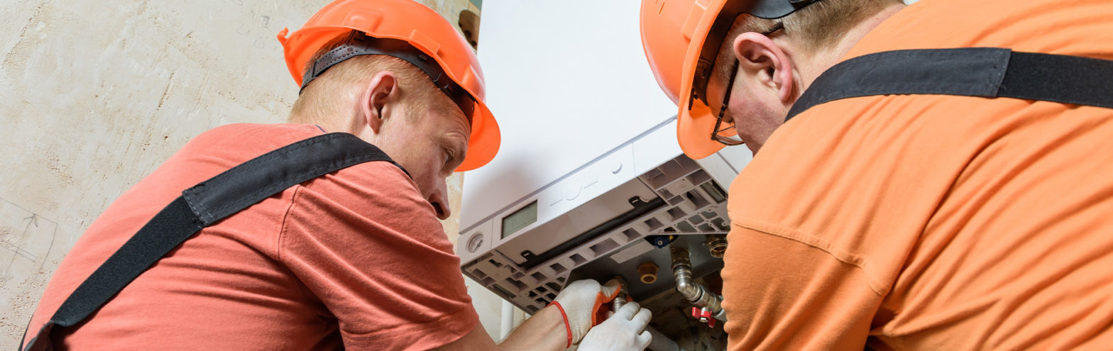 workman replacing a boiler on a wall