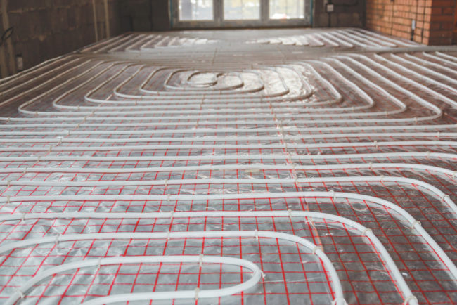 underfloor heating pipes and cables running throughout the floor surface
